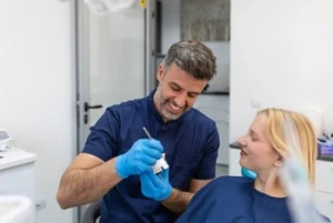 a smiling dentist discussing with a female patient