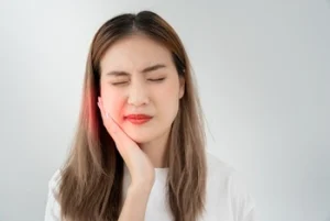 patient holding cheek showing signs of pain